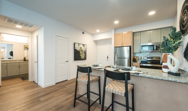 Settle into comfort at Cypress at Trinity Groves brightly lit kitchen with bar stools at the counter