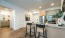 brightly lit kitchen with bar stools at the counter