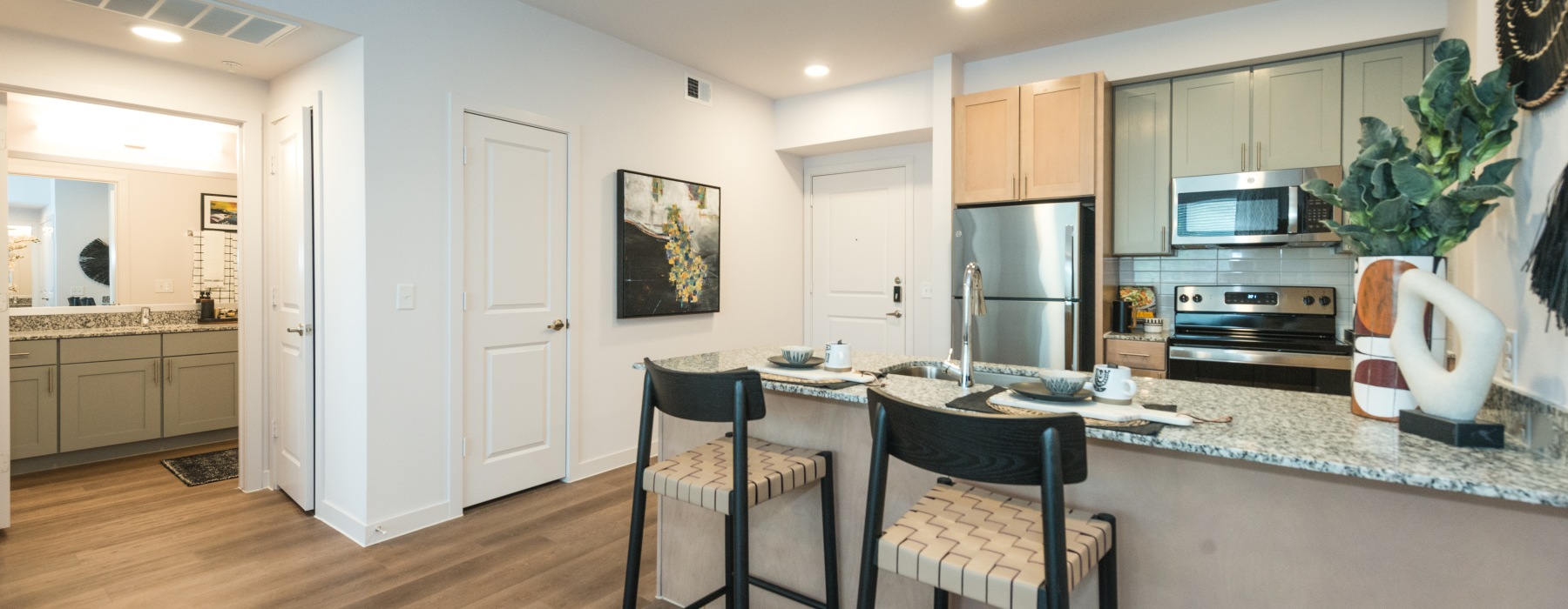 brightly lit kitchen with bar stools at the counter
